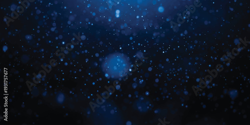 Abstract dark blue background with glowing particles and bokeh effect creating a sense of depth