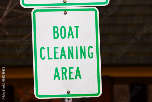 Close-up of a Boat Cleaning Area sign with green lettering on white. Mounted to a post, this notice informs boaters to clean equipment to prevent the spread of aquatic invasive species.
