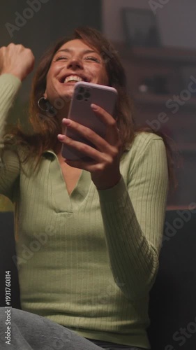 Surprised influencer with notification joy, Person in cozy setting excitedly responds to viral alert on device