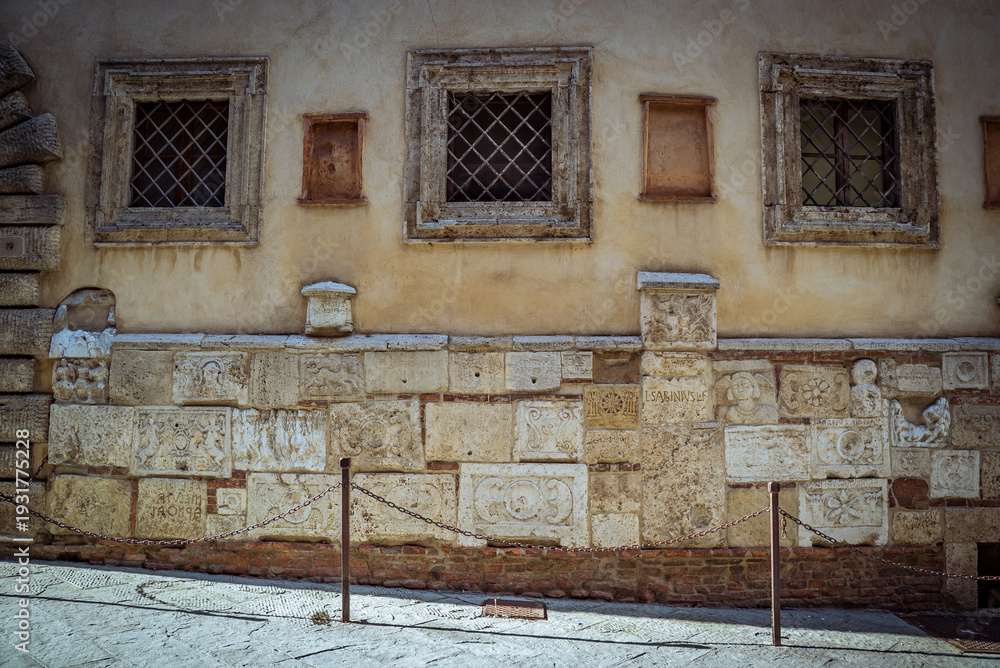 Fototapeta premium Montepulciano, Tuscany, Italy: Ancient stone wall with carved reliefs and windows