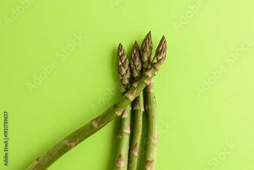 Fresh Green Asparagus Spears On Vibrant Green Background For Healthy Cooking And Food Photography