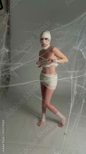 Mummy Woman Posing in Halloween Spiderweb Set