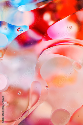 Close-up of the movement of oil droplets on the water surface. Colorful abstract macro background of oil drops on the water surface.
