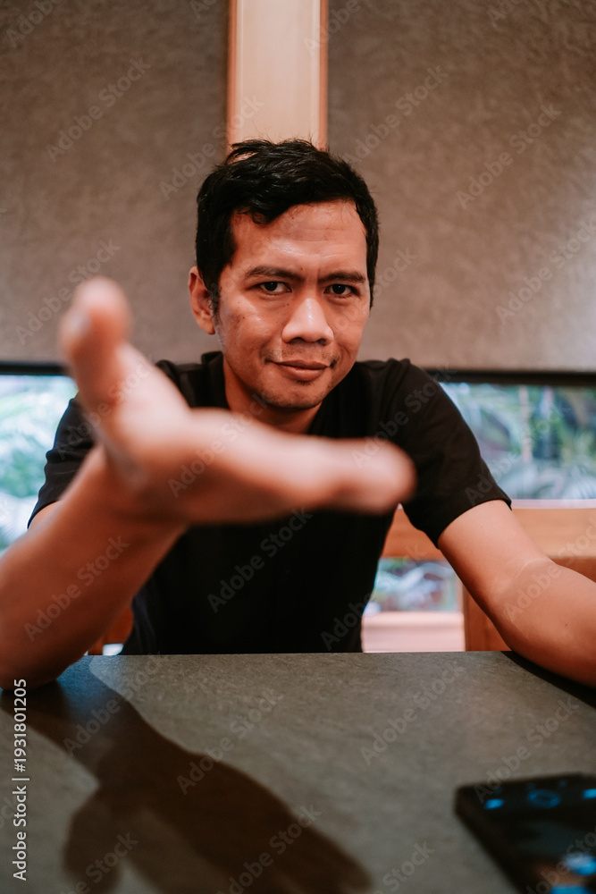 Obraz premium Young man making inviting gesture with outstretched hand