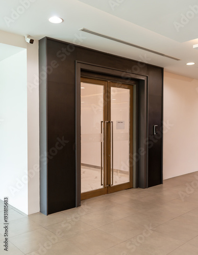 Modern office glass double door entrance with wooden frame and clean interior hallway, corporate building access, professional workspace design, contemporary architecture, business environment concept