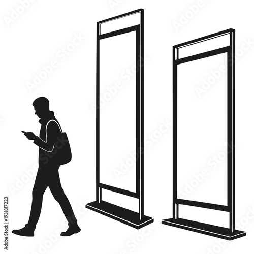 Person walking past two large vertical display screens while looking at their phone