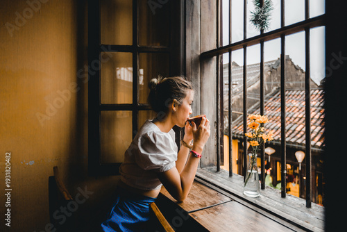 Coffee. Beautiful Girl Drinking Tea or Coffee in Cafe travel to Vietnam, Dark Warm Colors Toned