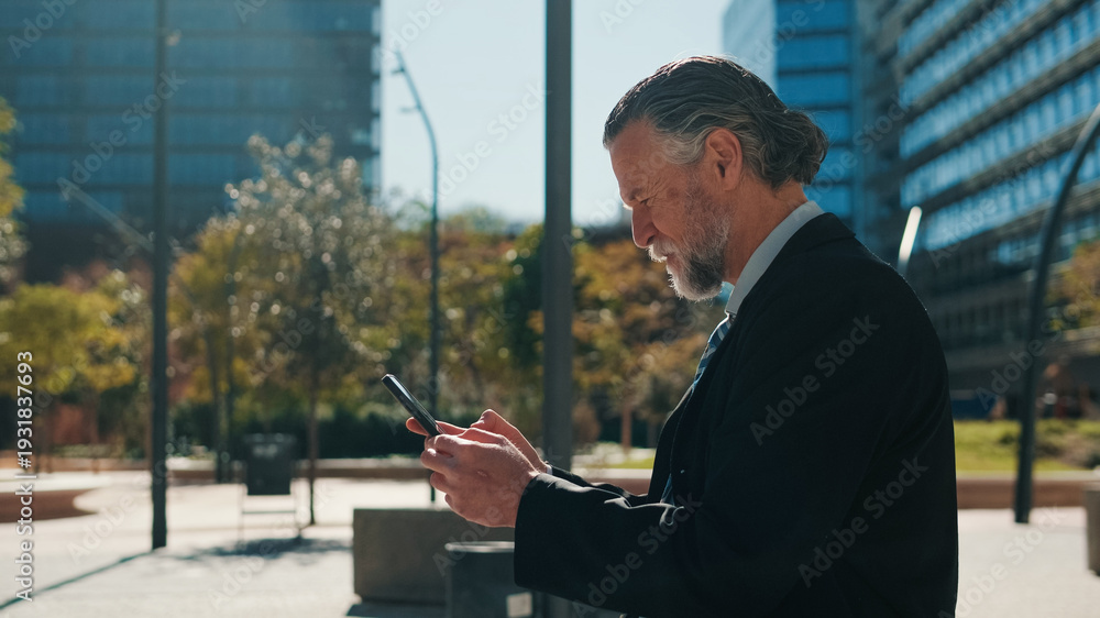 Fototapeta premium Professional Older Man Using Smartphone in City Park