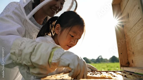 Asian girl with beekeeper checking beehive frames, looking at bees. Outdoor activity, learning about nature.