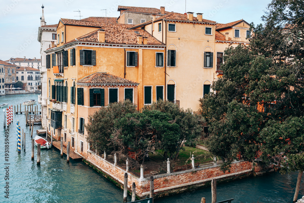 Obraz premium Building by the water in Venice showing classic architecture and greenery along the canal