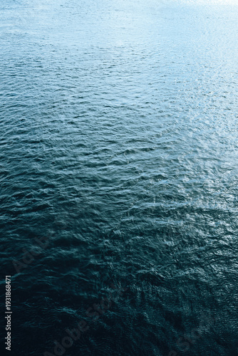 Calm rippling water surface with gentle waves and soft reflections, minimalist natural texture background.