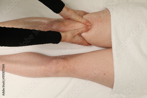 Fotografie Une personne reçoit un massage des jambes dans un cadre simple et relaxant à un