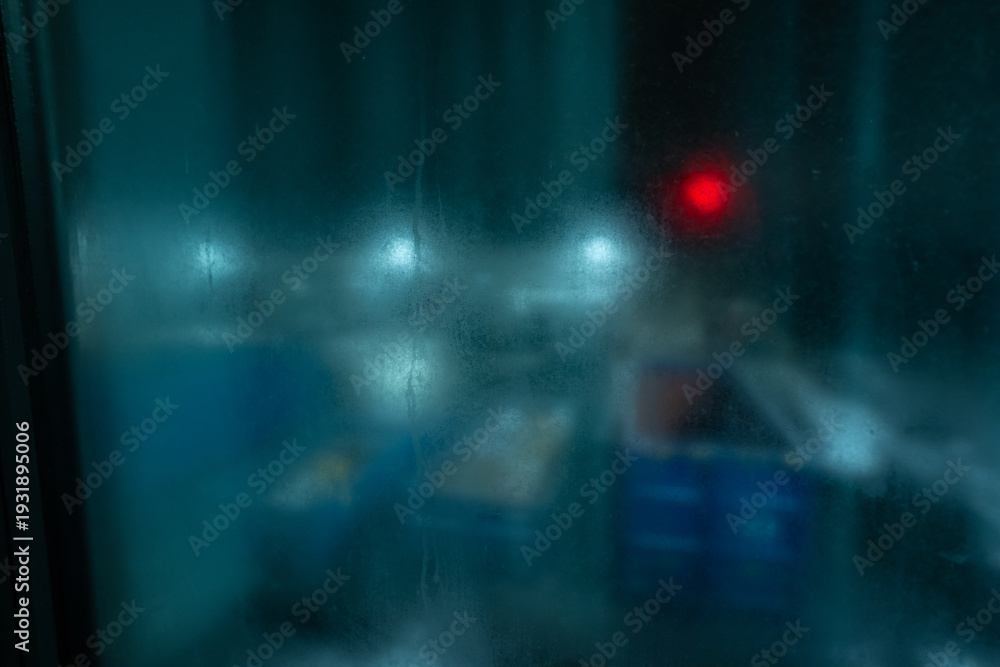 Fototapeta premium Atmospheric abstract view of colorful light spots through condensation during cold night