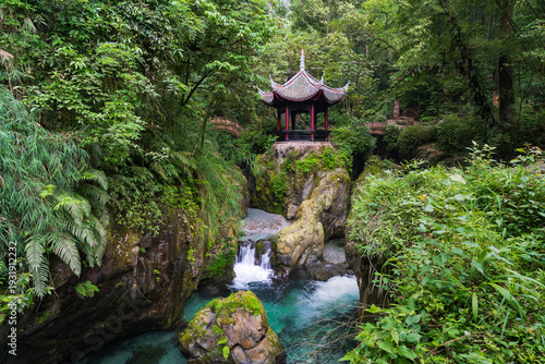 Traditional pavilion above mountain stream in lush subtropical forest, Mount Emei, China