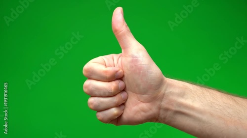 A hand giving a thumbs up in a VIDEO close-up shot on a modern device with a chroma key screen