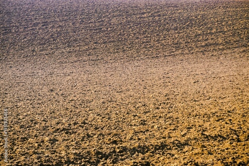 Frisch gepflügtes braunes erdiges Ackerfeld im Frühling als Hintergrund