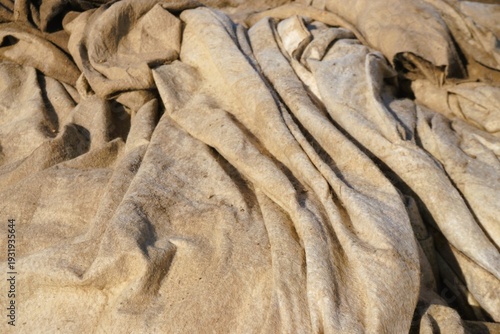 Beige-brauner Leinensacke mit Faltenmuster als Hintergrund