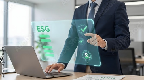 Businessman interacting with ESG virtual interface on laptop in modern office environment from a close-up viewpoint