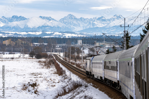 An intercity train winds its way through a snow-covered fields on route number 99 between Krakow and Zakopane, carrying tourists to the Tatra Mountains for their winter break