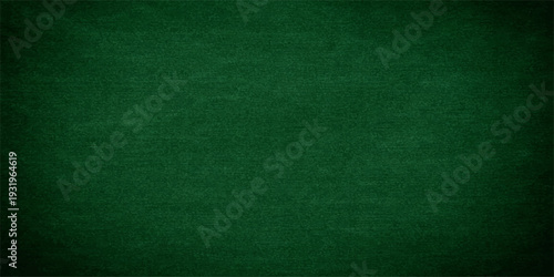 Empty green chalkboard background with a rough grunge texture and vintage paper pattern for a blank weathered material surface backdrop