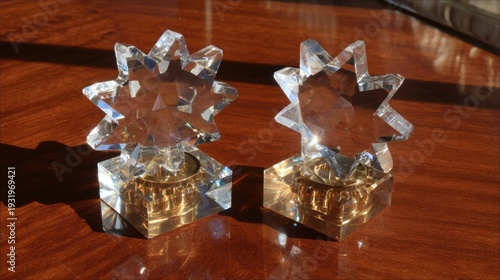 Pair of Crystal Star Candleholders Adorned with Golden Bases on a Polished Wooden Surface