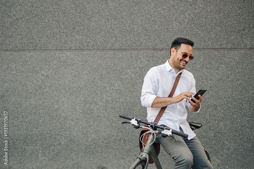 Wallpaper Mural Man using smartphone while commuting by bike in city Torontodigital.ca