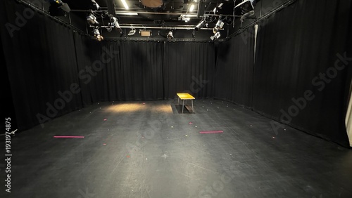 Tableau sur toile Empty black box theater studio stage with a single table under lighting rigs