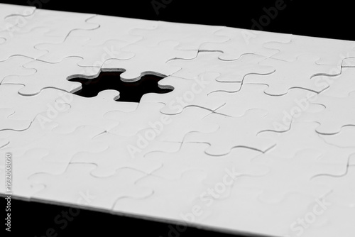 White Jigsaw Puzzle with One Missing Piece on Black Background