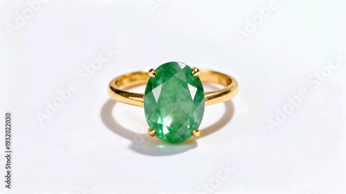 Wallpaper Mural A sophisticated gold ring featuring a large, faceted oval green jade gemstone in a four-prong setting, isolated on white. Torontodigital.ca