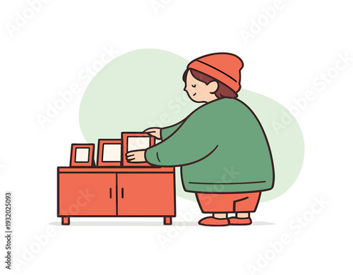 Cozy person arranges photo frames on a cabinet, frames leaned evenly, rhythm slow and mindful. | photo frames, arranging photos,