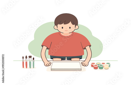 Young boy happily engaged in painting with colorful paints and brushes on paper