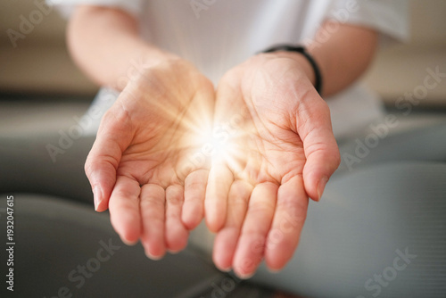 Give to Gain Symbol of Empowerment and Sharing. Woman Holding a Glowing Light in Her Open Hands While Sitting in Yoga Lotus Pose