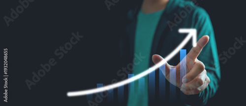 Close up of business professional touching virtual bar chart with upward arrow on dark background, representing financial growth, profit increase, performance analytics and business success strategy.