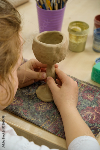 Child sculpts the product from raw clay