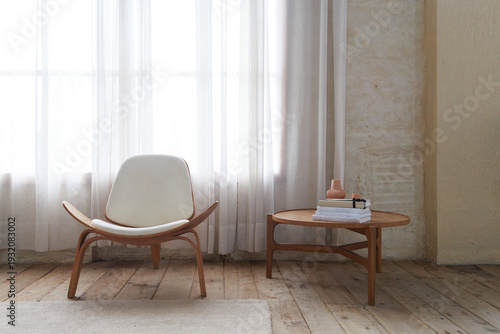 Minimalist living room with wooden designer chair and coffee table by a bright window