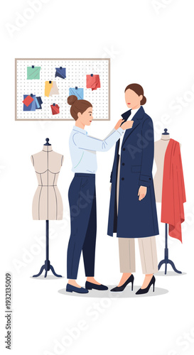 A fashion designer meticulously adjusts a dark blue trench coat on a standing model, surrounded by mannequins and a mood board in a studio.