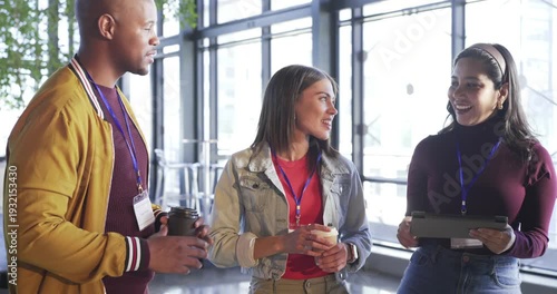 Greeting sparking Diverse coworkers tapping tablet by windows laughing and inviting senior feedback