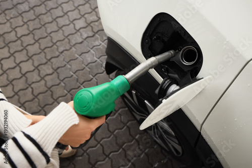 Young woman filling up car ...