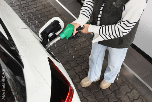 Young woman filling up car ...