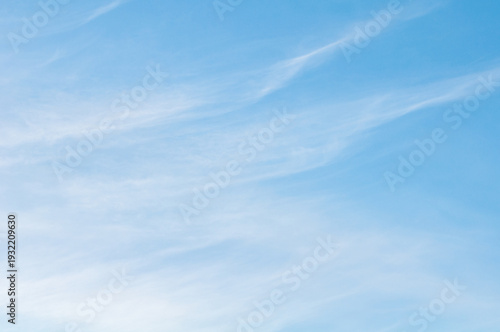 Tableau sur toile Soft wispy cirrus clouds stretching across a clear blue sky creating a calm mini