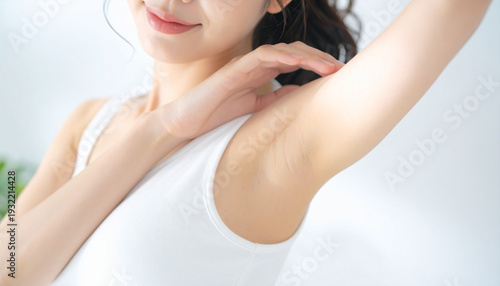 白背景で脱毛後の脇を見せる若い女性のクローズアップ　ボディケア・美容イメージ