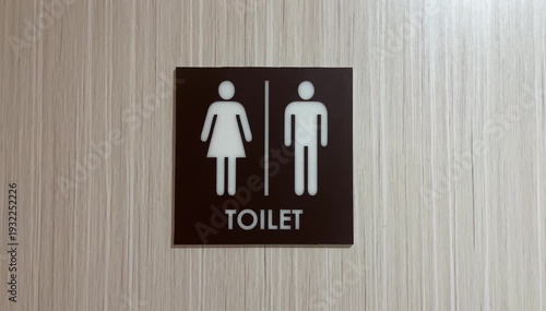 Side view of unisex restroom sign on wooden wall or door. brown, black, white. Public toilet sign showing facilities for male or female. icon. front. close up.