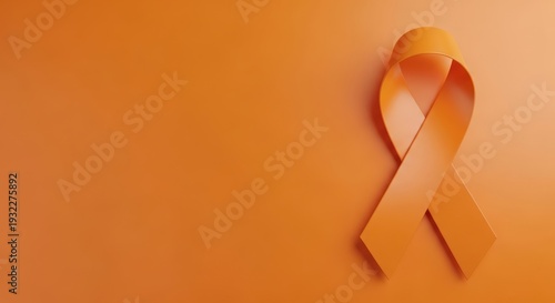 Orange ribbon symbolizing awareness on a matching background surface.