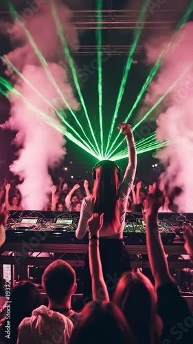 Young female DJ performing live set at underground electronic music festival with green laser show