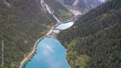 Drone view of Jiuzhaigou National Park in autumn in Sichuan Province China. It features cascading waterfalls, turquoise blue lakes, and stunning mountain valleys. 4K real time footage travel concept