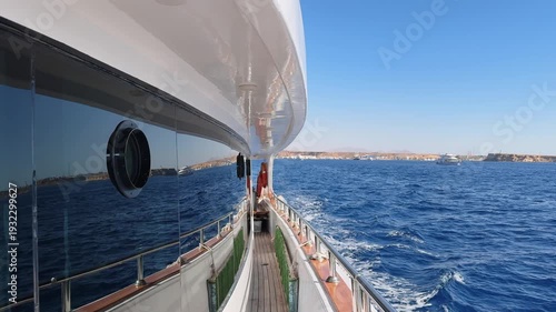 Luxury yacht side deck view with tinted window leaving sea port