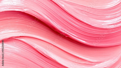 Pink paint swirls on a canvas creating a smooth texture and flow
