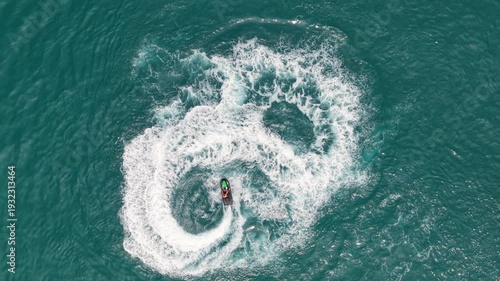 Aerial Top Down Drone View of Jet Ski Rider Doing Circles and Tricks on Turquoise Sea