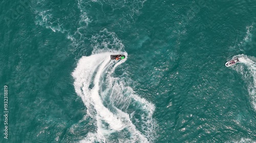 Slow Motion Aerial Top Down View of Jet Ski Rider Making Sharp Turn on Turquoise Sea