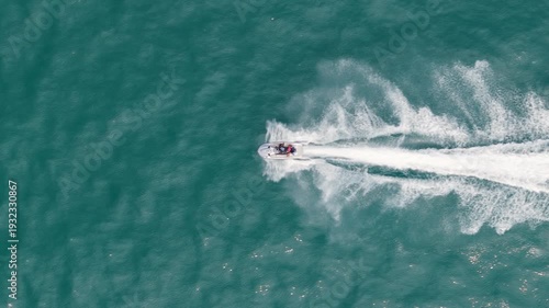 Slow Motion Aerial Drone Chase Shot of Single Jet Ski Racing at High Speed on Turquoise Sea